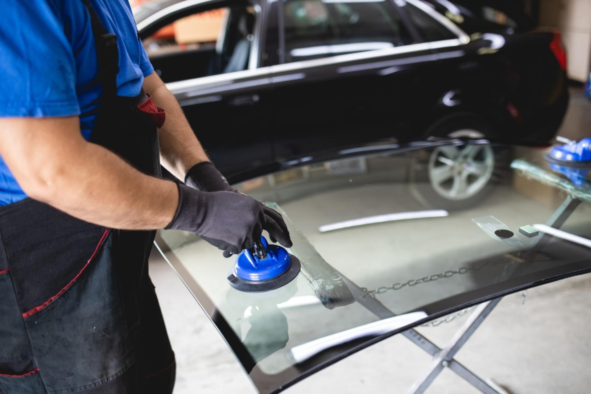 A technician buffs a glass windshield