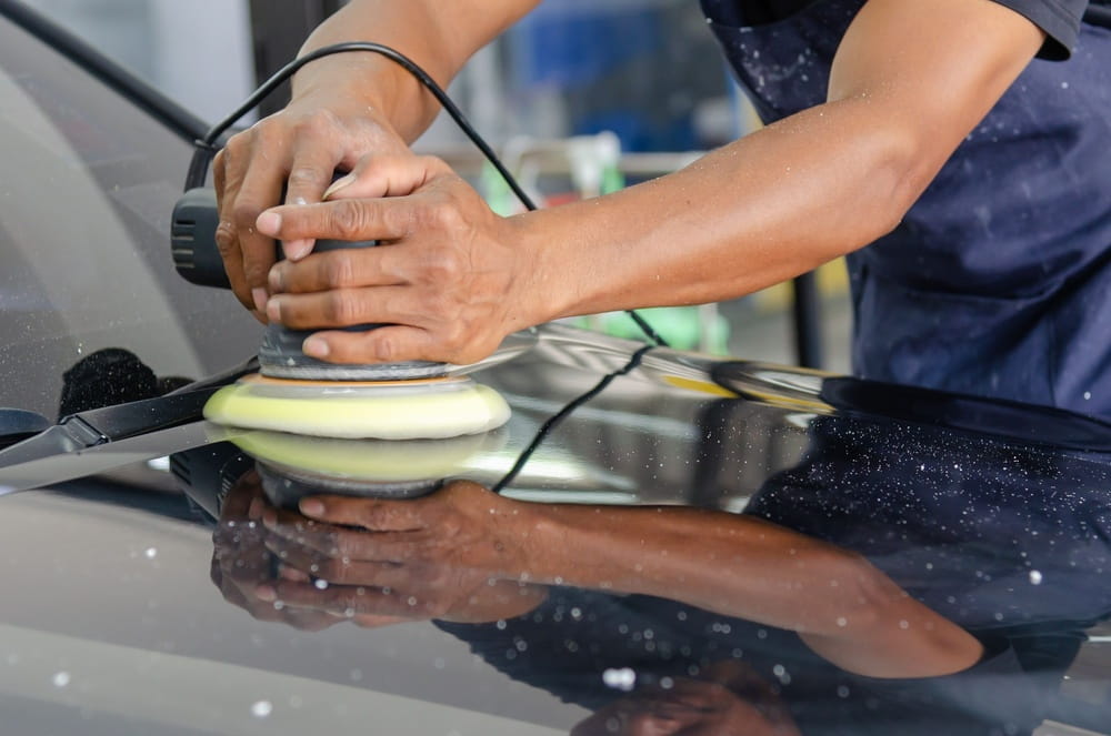 technician buffing paint on auto